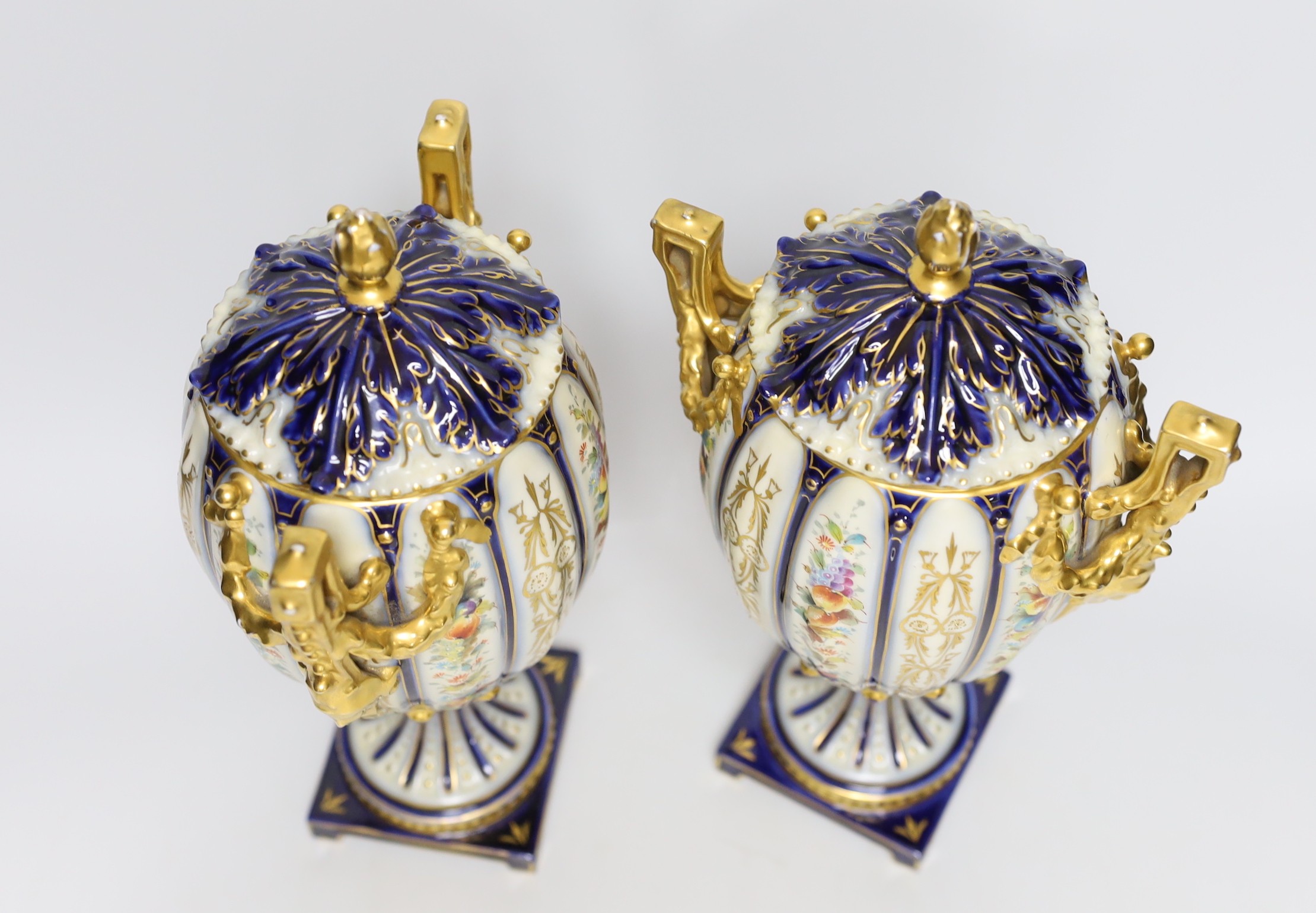 A pair of 19th century continental porcelain gilt and floral urns and covers, 29cms high